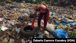 Aïcha Traoré, jeune créatrice, récupère des pneus usés dans une décharge, à Conakry, Guinée, 13 septembre 2018. (VOA/Zakaria Camara)