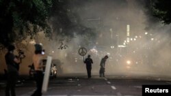 Agentes federales lanzan gases lacrimógenos y otros materiales no letales a manifestantes durante una protesta contra la desigualdad racial en Portland, Oregón, el 19 de julio de 2020.
