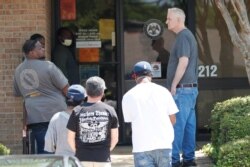 People wait outside a WIN job center in Pearl, Mississippi, April 21, 2020. WIN lobbies are closed statewide during the COVID-19 pandemic, but some staff continue to work with clients by providing unemployment benefits applications.