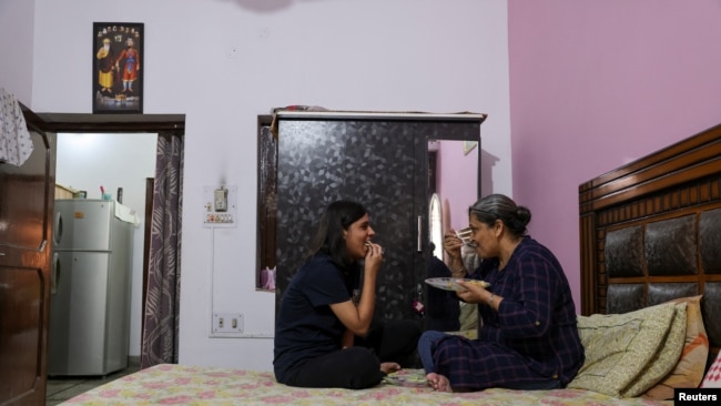 Jashandeep Kaur, 22, talks to her mother Ripudaman Kaur, 52, as they eat at their house in Dera Bassi, India, August 14, 2022. REUTERS/Anushree Fadnavis