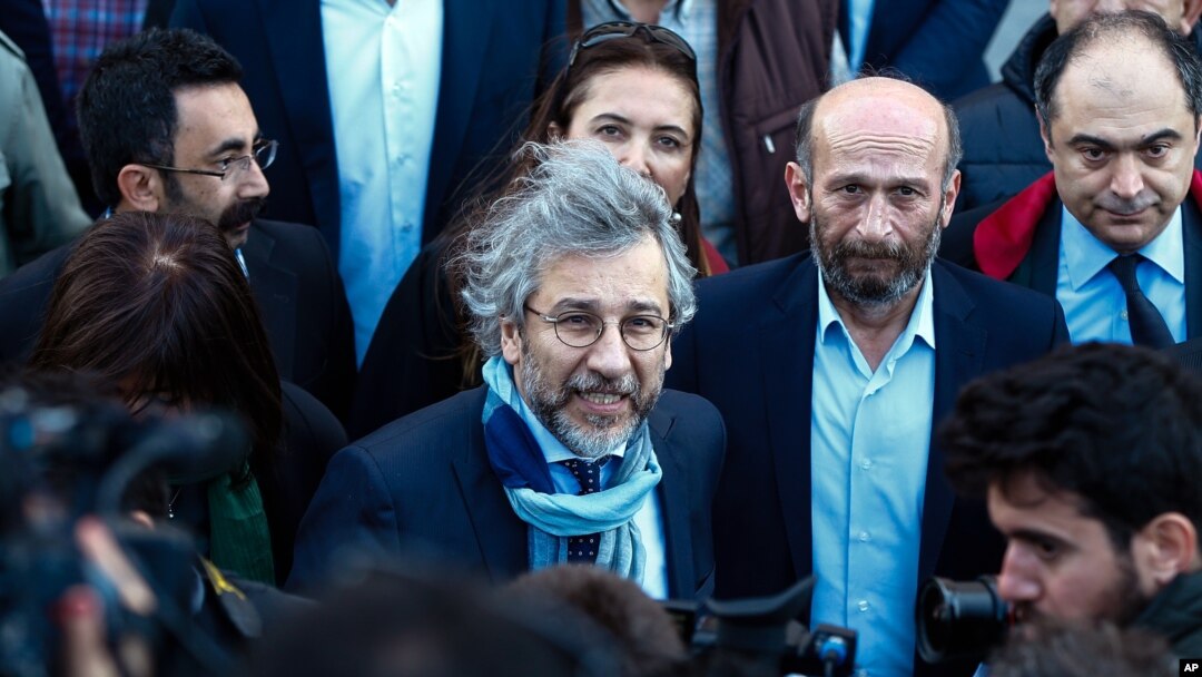 Can Dundar, the editor-in-chief of opposition newspaper Cumhuriyet, center-left, and Erdem Gul, the paper's Ankara representative, center-right, speak to the media before the start of their trial in Istanbul, April 1, 2016.