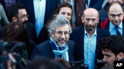 Can Dundar, the editor-in-chief of opposition newspaper Cumhuriyet, center-left, and Erdem Gul, the paper's Ankara representative, center-right, speak to the media before the start of their trial in Istanbul, April 1, 2016.