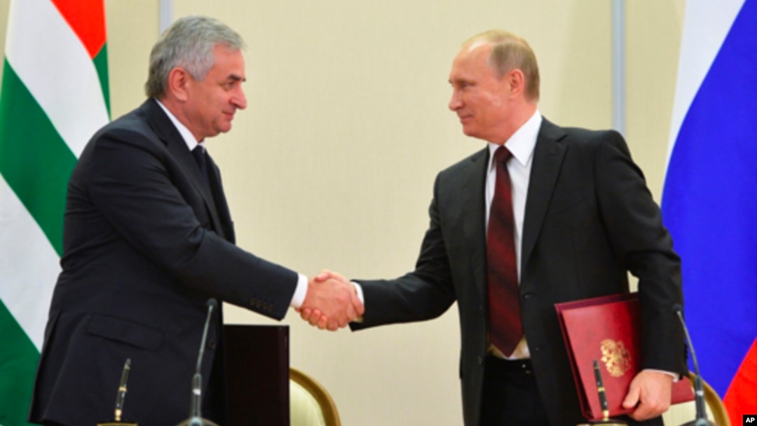 Russian President Vladimir Putin (r) and leader of Georgia's breakaway province of Abkhazia Raul Khadzhimba shake hands at a signing ceremony in the Bocharov Ruchei residence in Sochi, Russia, Nov. 24, 2014.