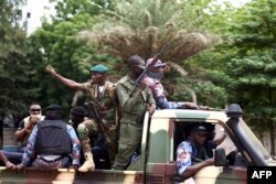 FILE - Malian soldiers drive through the streets of Bamako, Mali, Aug. 19, 2020, the day after rebel troops seized Malian President Ibrahim Boubacar Keita and Prime Minister Boubou Cisse in a dramatic escalation of a months-long crisis.