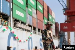 FILE - A soldier stands guard beside the Cosco Wellington, the first container ship to depart after the inauguration of the China Pakistan Economic Corridor port in Gwadar, Pakistan, Nov. 13, 2016.