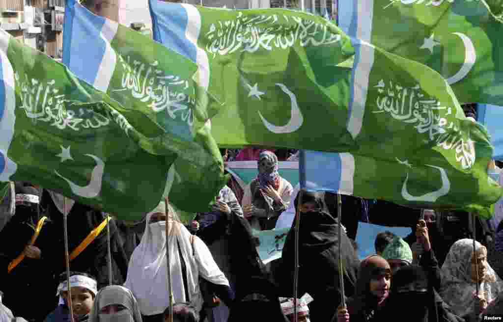 Supporters of the political and religious party Jamaat-e-Islami hold party flags as they march during a rally to mark Kashmir Solidarity Day in Lahore, Pakistan. 