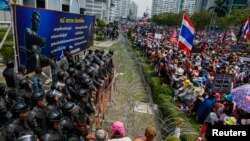 反政府抗议者在总理英拉临时办公室所在的泰国国防部大楼外与军人对峙。（2014年2月19日）