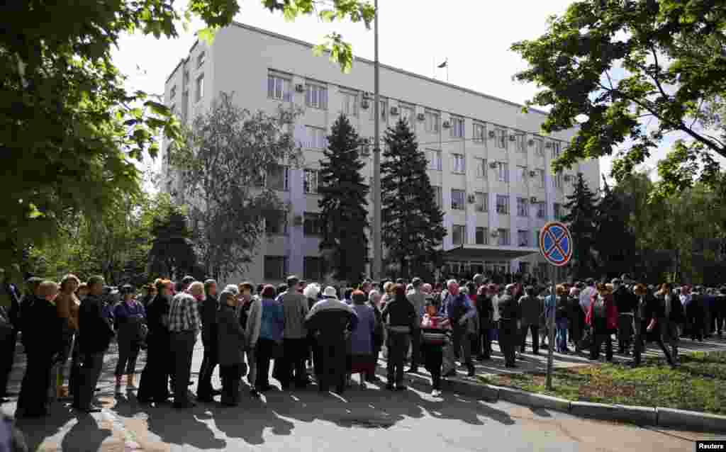 لوگوں کی ایک لمبی قطار ووٹ ڈالنے کے لیے پولنگ اسٹیشن کے باہر اپنی باری کا انتظار کر رہی ہے۔
