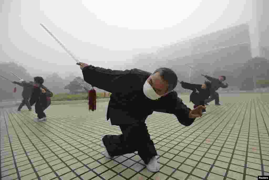 A man wearing a mask exercises on a hazy morning in Fuyang, Anhui province, China.