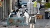 FILE - Forensics of the French police search for evidence Nov. 18, 2015, outside a building in the northern Paris suburb of Saint-Denis, where French police special forces raided an apartment.