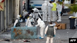 FILE - Forensics of the French police search for evidence Nov. 18, 2015, outside a building in the northern Paris suburb of Saint-Denis, where French police special forces raided an apartment.