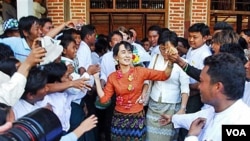 Aung San Suu Kyi menyalami pendukungnya di desa Kyit Tee, kota Myaing, Burma Tengah (31/1). Suu Kyi batal mengadakan kampanye di stadion sepakbola setempat.