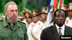 Le président cubain Fidel Castro reçoit le président du Zimbabwe, Robert Mugabe, au palais de la Révolution à La Havane, le 16 juillet 2002.