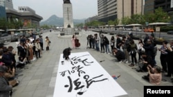 Južnokorejski kaligraf Kang Bjung In ispisuje poruke dobe volje tokom skupa za ujedinjenje Severne i Južne Koreje u Seulu, Južna Koreja, 26 aprila 2018.