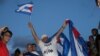 Una joven hace la señal de "Libertad" en camino a la manifestación a través de la Calle 8 en Miami, Florida, en apoyo a las protestas sucedidas el domingo 11 de julio de 2021. Foto: Luis F. Rojas, VOA.