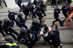 Protesters clash with French riot police during a demonstration to mark the first anniversary of the "yellow vests" movement in Nantes, France, Nov. 16, 2019.
