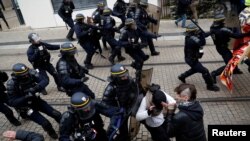 Protesters clash with French riot police during a demonstration to mark the first anniversary of the "yellow vest" movement in Nantes, France, Nov. 16, 2019. 