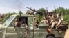 FILE - In this image grab from handout video footage released by the Sudanese paramilitary Rapid Support Forces (RSF) on April 23, 2023, fighters ride in the back of a pickup truck in the East Nile district of greater Khartoum, Sudan.