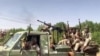 FILE - In this image grab from handout video footage released by the Sudanese paramilitary Rapid Support Forces (RSF) on April 23, 2023, fighters ride in the back of a pickup truck in the East Nile district of greater Khartoum, Sudan.