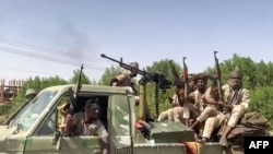 FILE - In this image grab from handout video footage released by the Sudanese paramilitary Rapid Support Forces (RSF) on April 23, 2023, fighters ride in the back of a pickup truck in the East Nile district of greater Khartoum, Sudan.