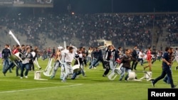 Besiktas fans throw plastic chairs onto the pitch during the Turkish Super League derby soccer match between Besiktas and Galatasaray at Ataturk Olympic Stadium in Istanbul September 22, 2013. 