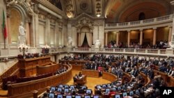 Members of parliament stand up, background right, to vote in favor of a bill that grants adoption rights to same-sex couples at the parliament in Lisbon, Feb. 10, 2016. 