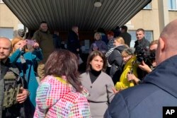 Ukraine’s Prosecutor General Iryna Venediktova speaks with refugees outside a processing center in Lviv, Ukraine on March 22, 2022. (AP Photo/Erika Kinetz).