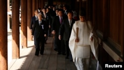 Serombongan anggota parlemen Jepang dipandu oleh pendeta Shinto saat mengunjungi Tugu Yasukuni di Tokyo (22/4).