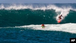 A surfer rides a wave at Waimea Bay Beach Park, near Haleiwa, Hawaii, on the North Shore of Oahu, Oct. 28, 2015. 