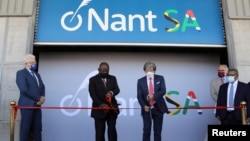 South African President Cyril Ramaphosa (C-L) and South African-born American billionaire Patrick Soon-Shiong cut the ribbon during the launch of NantSA, a future vaccine manufacturing facility, in Cape Town, South Africa, Jan. 19, 2022. 