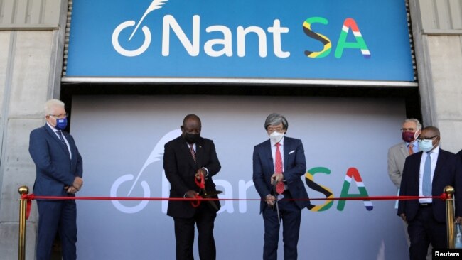 South African President Cyril Ramaphosa (C-L) and South African-born American billionaire Patrick Soon-Shiong cut the ribbon during the launch of NantSA, a future vaccine manufacturing facility, in Cape Town, South Africa, Jan. 19, 2022.