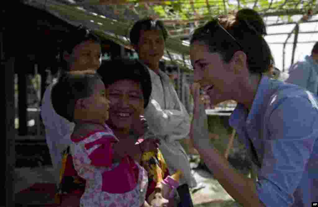 Denmark’s crown Princess Mary, right, waves her hand to Buddhist woman and her baby during a visit to a Buddhist resettlement village in Sittwe, Rakhine State, Myanmar, Sunday, Jan. 12, 2014. Crown Princess Mary, accompanied by Denmark’s Minister for Deve