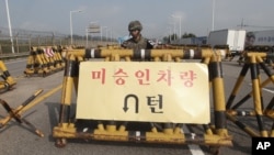 A South Korean amy soldier stands guard behind a barricade on Unification Bridge, which leads to the demilitarized zone, near the border village of Panmunjom in Paju, South Korea, Aug. 22, 2015.