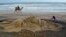 Sand artist Sudarshan Pattnaik works on a sculpture about Cyclone Phailin that hit Puri in the eastern Indian state of Odisha.