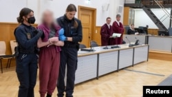 FILE - One of five members of the "United Patriots" group arrives for the start of their trial in a Koblenz courtroom, Germany, May 17, 2023 (defendant's face blurred at source due to German privacy laws).