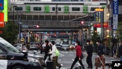 People walk along a pedestrian crossing Nov. 3, 2020, in Tokyo. 
