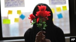 A survivor of sexual assault holds plastic flowers after attending a meeting with the group "Sisters in Strength" in the Brooklyn borough of New York, March 14, 2019. 
