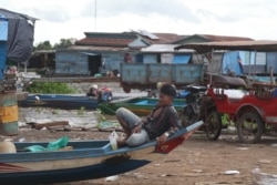 Sim Vantha, a local 28-year-old fisherman, sits on the edge of his boat awaiting a fishing expedition in the Tonle Sap Lake, Kampong Chhnang province, Cambodia, August 9, 2020 (Sun Narin/VOA Khmer)