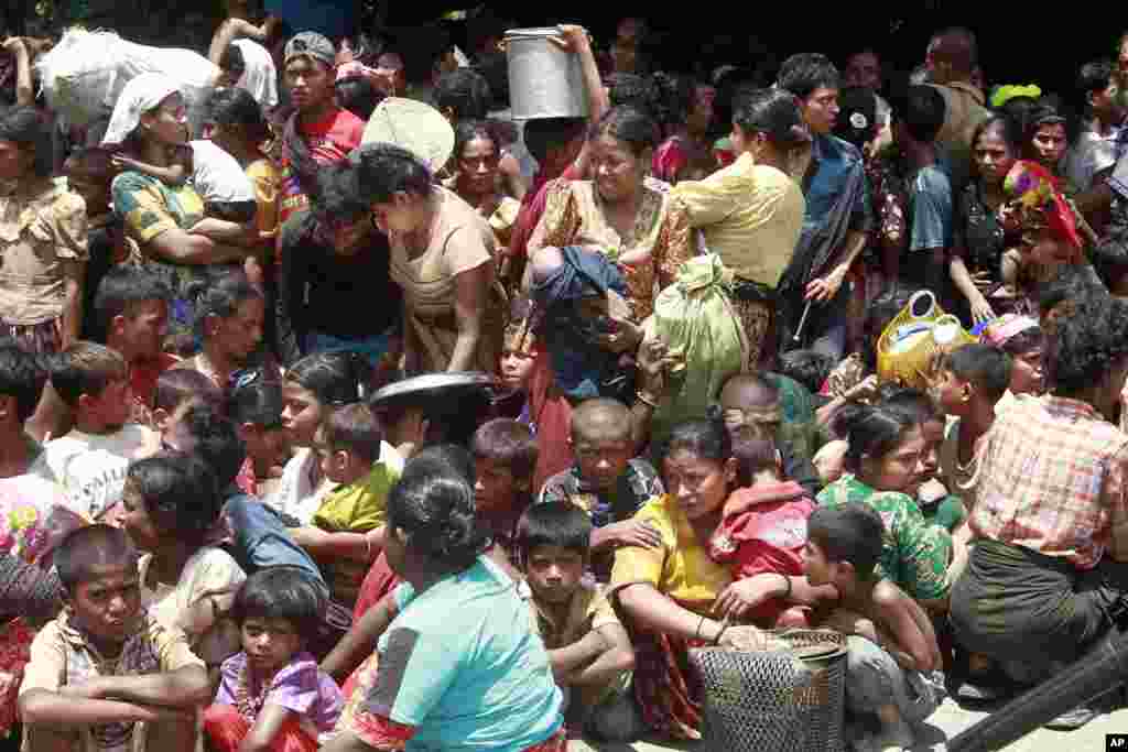 Phụ nữ v&agrave; trẻ em tại c&aacute;c l&agrave;ng tụ tập trước khi được đưa tới c&aacute;c khu vực an ninh ở Sittwe, thủ phủ của bang Rakhine, nơi c&oacute; những vụ bạo động phe ph&aacute;i, 12/6/2012.