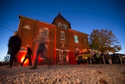 Guests arrive at the The Dent Schoolhouse haunted attraction, Thursday, Oct. 29, 2015, in Cincinnati. The haunt, owned and operated by Bud Stross and Josh Wells, two high school friends, inhabits a late 19th century schoolhouse they've renamed “The Dent S