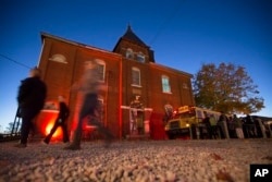 Guests arrive at the The Dent Schoolhouse haunted attraction, Thursday, Oct. 29, 2015, in Cincinnati. The haunt, owned and operated by Bud Stross and Josh Wells, two high school friends, inhabits a late 19th century schoolhouse they've renamed “The Dent S