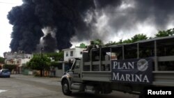 A truck of the Mexican Navy is seen as smoke from a fire at Mexico's state-owned oil firm Pemex Salina Cruz refinery billows in the background, in Salina Cruz, Oaxaca state, Mexico, June 14, 2017. 