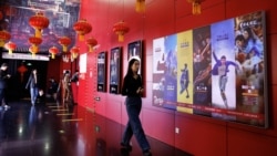 Seseorang berjalan melewati poster film di Capital Cinema di Beijing, China, 21 Februari 2024. (Foto: Tingshu Wang/Reuters)