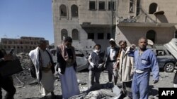 Yemeni Huthis gather around the body of a man killed by air strikes at a detention centre in the capital Sanaa on Dec. 13, 2017.