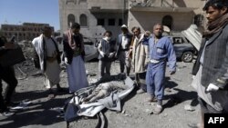 Yemeni Huthis gather around the body of a man killed by airstrikes at a detention center in the capital Sanaa, Dec. 13, 2017.