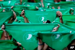 FILE - In this April 10, 2018, file photo, abortion-rights demonstrators raise green handkerchiefs during a rally in front of the National Congress in Buenos Aires, Argentina. (AP Photo/Natacha Pisarenko, File)