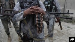 FILE - Afghan security forces guard a checkpoint in Spein Boldak at the border with Pakistan, Kandahar province, Afghanistan, Jan. 25, 2016. U.S. and NATO allies have conducted nearly 100 counterterrorism strikes in Afghanistan this year that mostly targeted Islamic State fighters, they said.