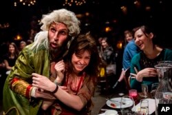 This undated theater image released by The Hartman Group shows Blake DeLong, left, with an audience member in "Natasha, Pierre and the Great Comet of 1812," a dinner theater performance in New York.