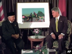 FILE - President Bill Clinton and Indonesian President Suharto meet at the 1997 APEC Summit in Vancouver, British Columbia, Nov. 24, 1997.