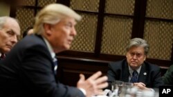 White House strategist Steve Bannon listens at right as President Donald Trump speaks during a meeting on cyber security in the Roosevelt Room of the White House in Washington, Jan. 31, 2017.